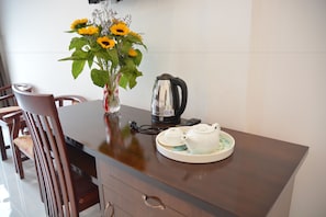 Una mesa de comedor con un florero de girasoles, una tetera y teteras.