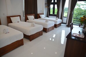 A hotel room with three wooden beds, white linens, and a view of greenery outside. - Horizon 2 Villa Hoi An (Da Nang)