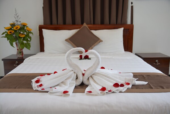 A neatly made bed with a brown bedspread, white pillows, and a decorative pillow on the headboard. - Horizon 2 Villa Hoi An (Da Nang)