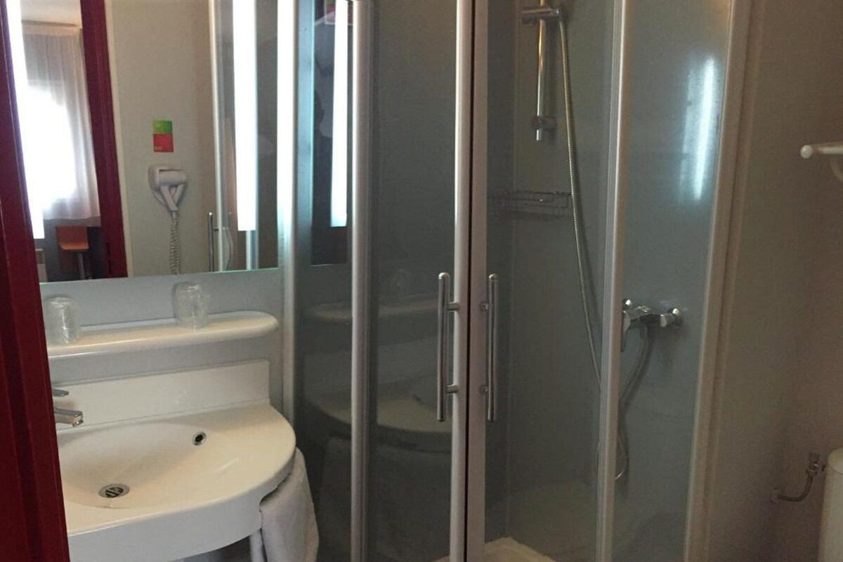 Ein Badezimmer mit Duschkabine, Waschbecken in Weiß und Toilette.