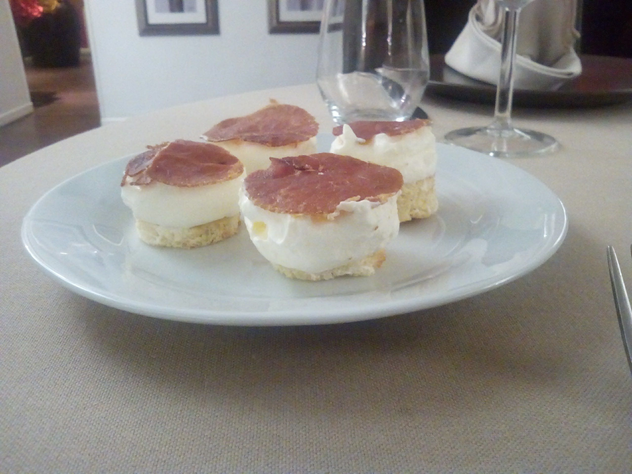A plate with four small pastries on a table.