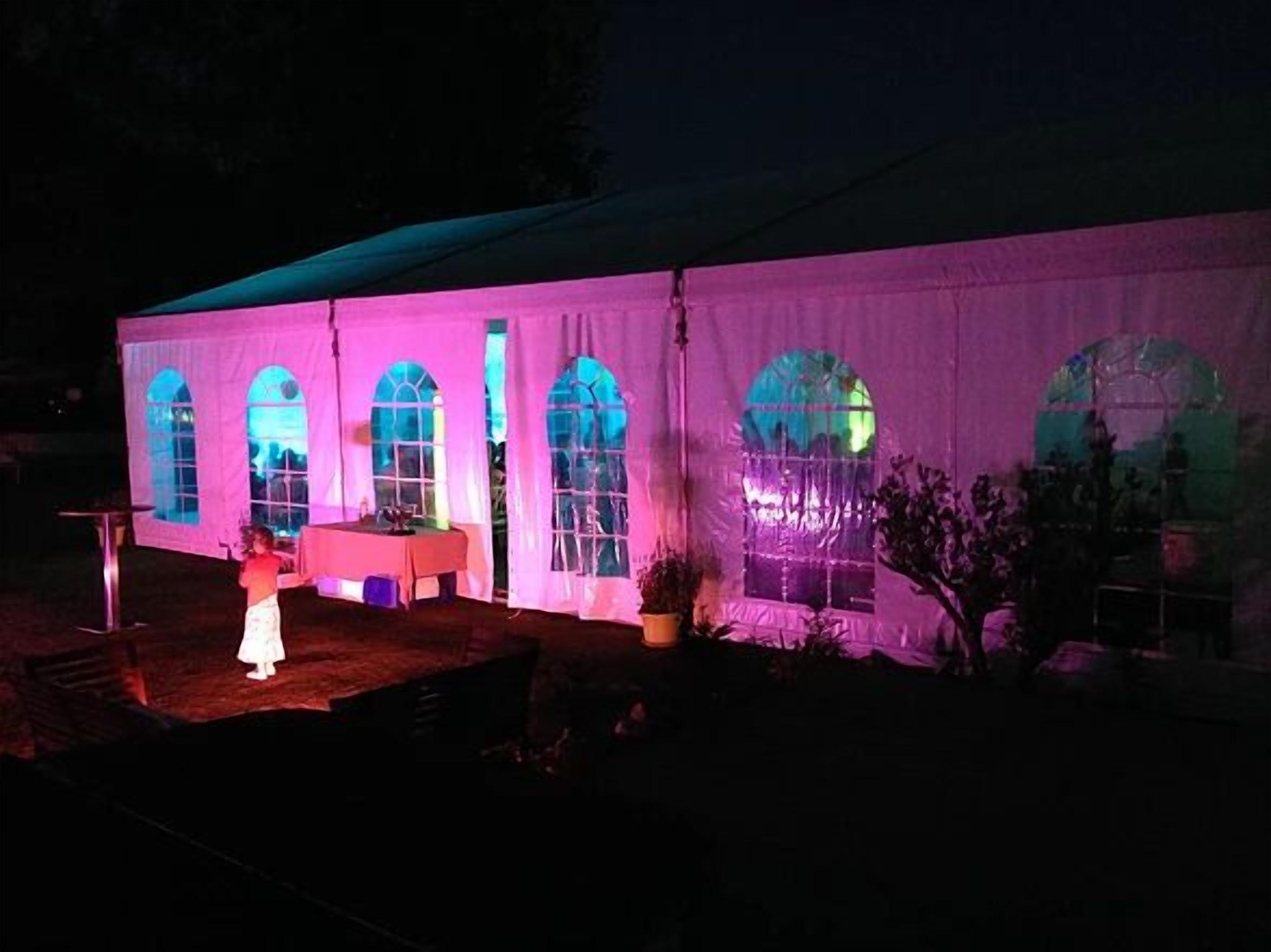 A tent with arched windows and a table set up outside.