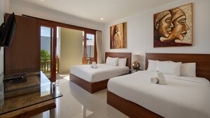 A hotel room with two beds, a TV, and artwork on the wall. - Daha Mansions Seminyak (Seminyak)
