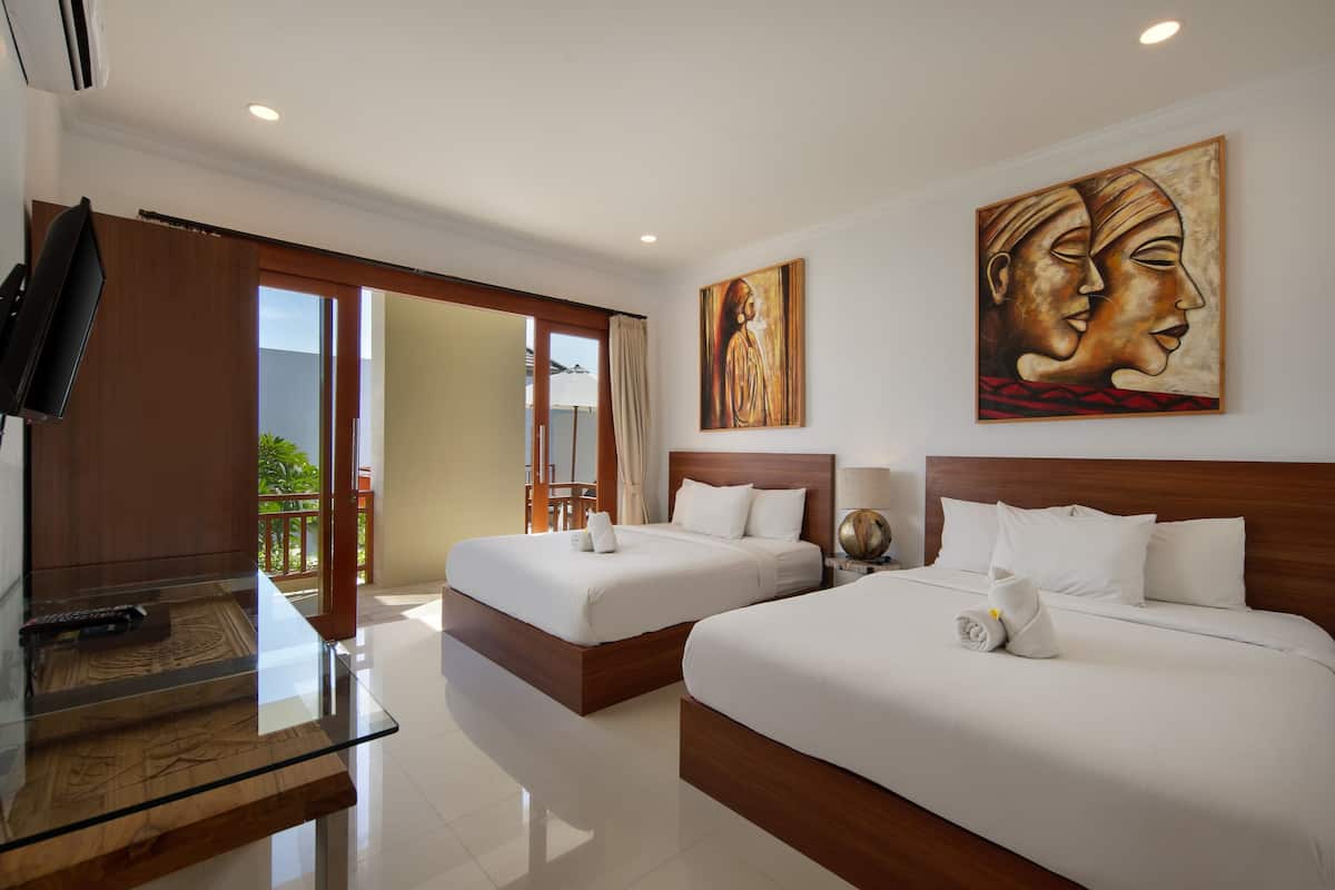 A hotel room with two beds, a TV, and artwork on the wall.