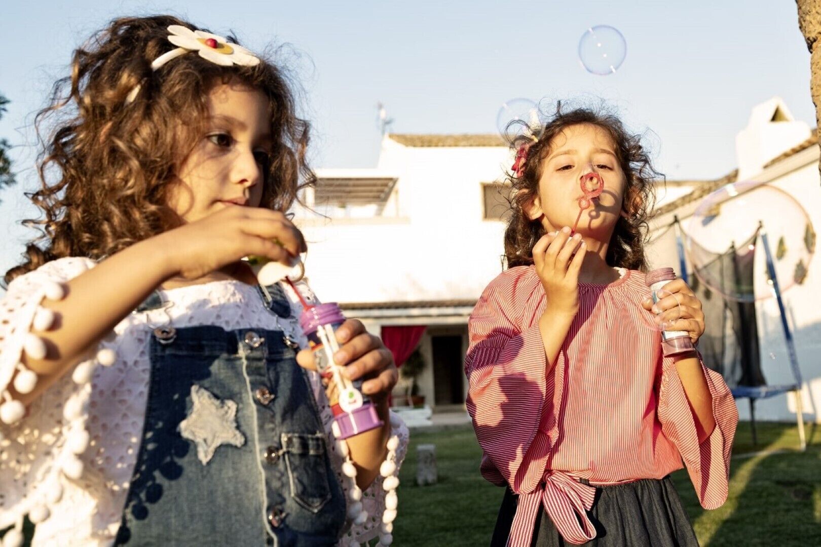 Two children playing with bubbles outdoors.