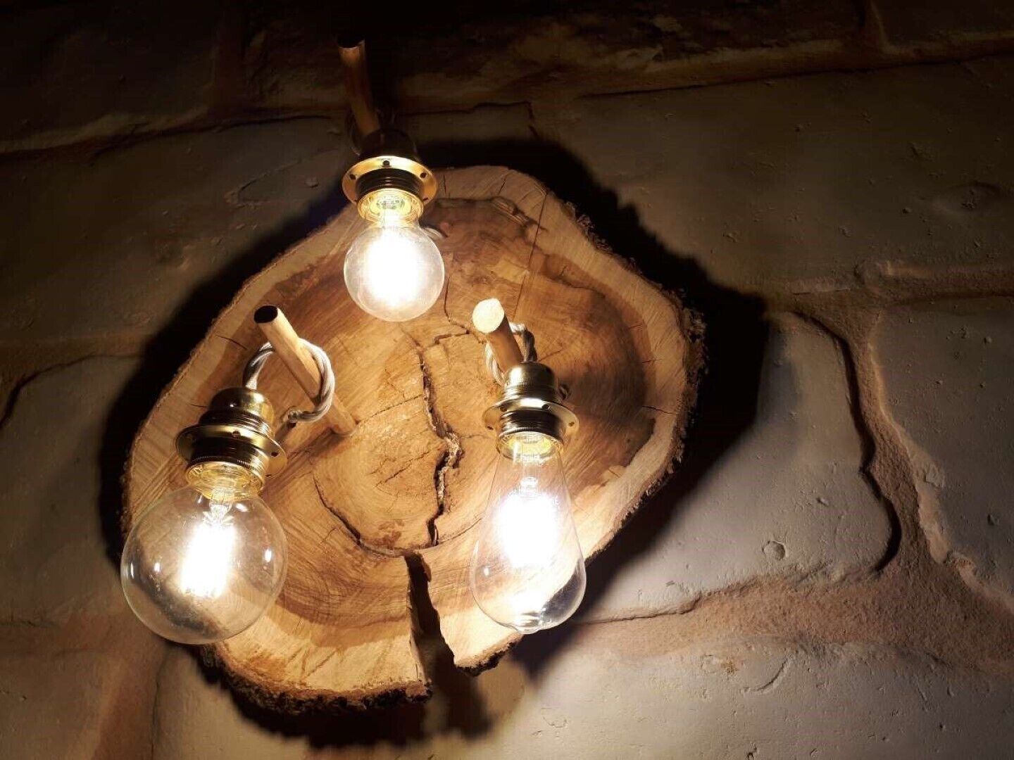 Eine Holztischplatte mit drei hell leuchtenden Glühbirnen.