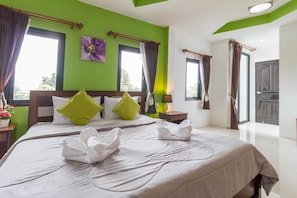 A hotel room with a large bed, green walls, and a view of the outdoors. - Samed Big Tree (Rayong)