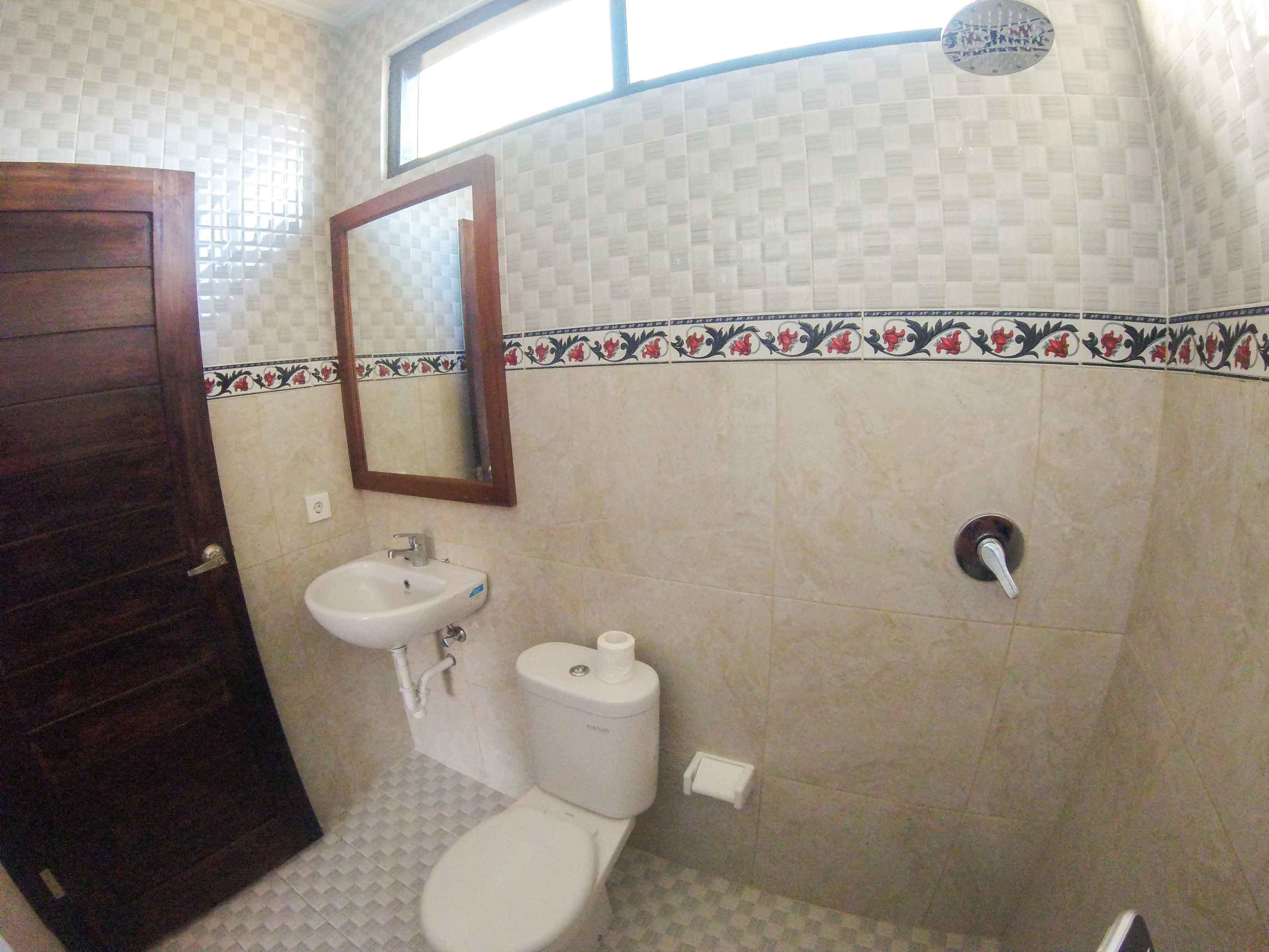 Un baño con inodoro, lavabo y espejo.