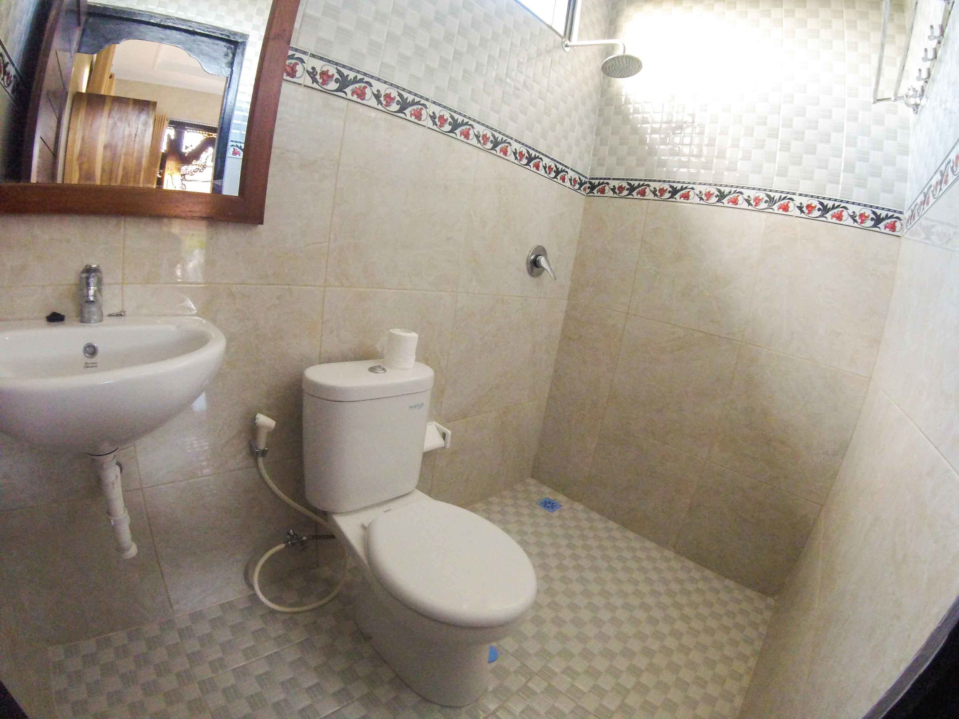 A bathroom with a sink, toilet, and shower.