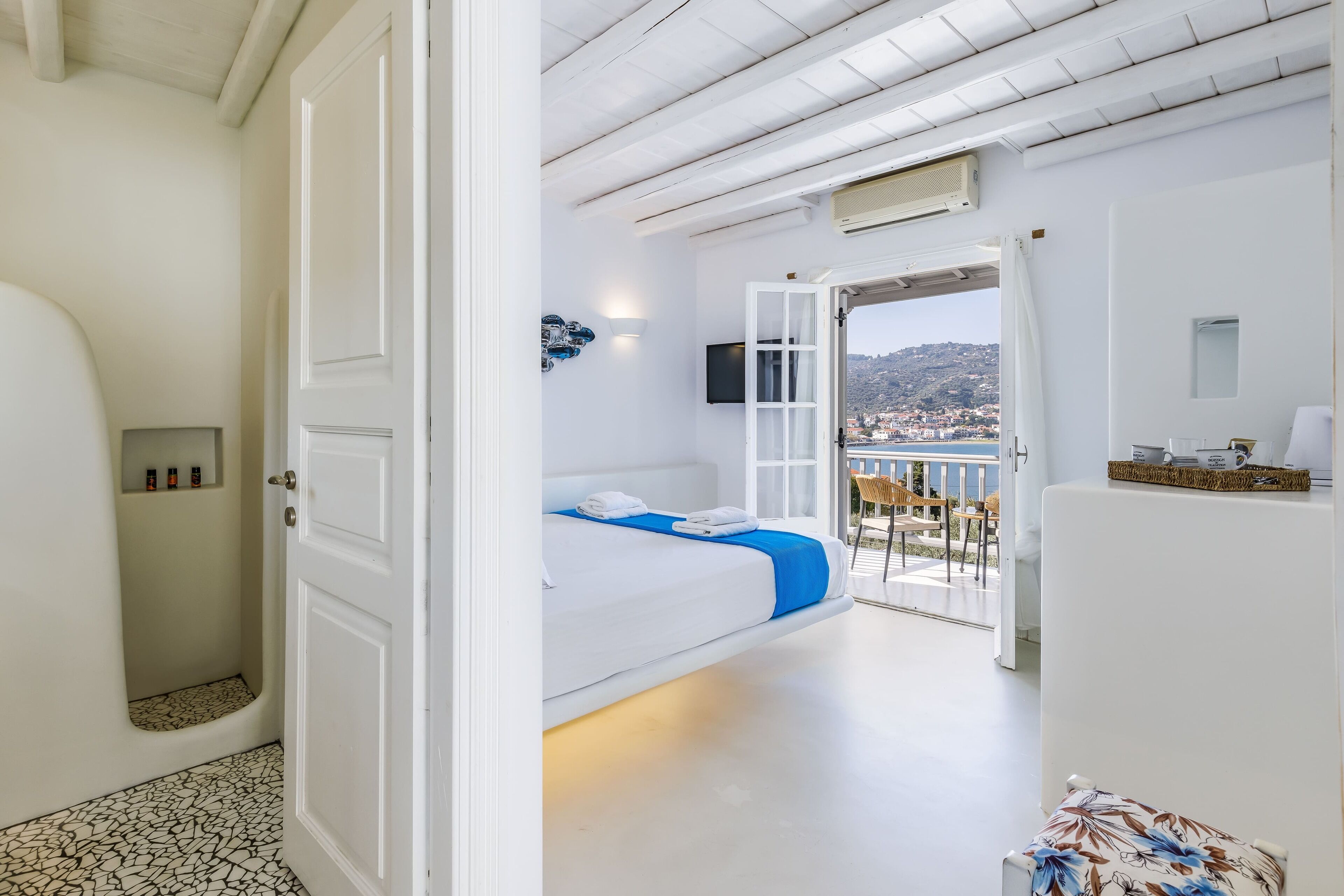 Una habitación con cama, ducha y balcón con vistas.
