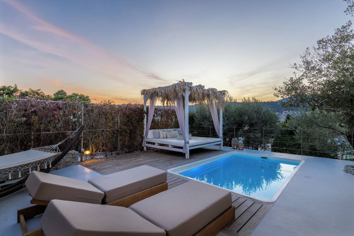 Un espace aménagé au bord de la piscine, doté d’un auvent, de chaises longues et d’un hamac.
