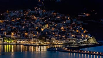 Un pueblo costero de noche con edificios iluminados a lo largo del paseo marítimo.