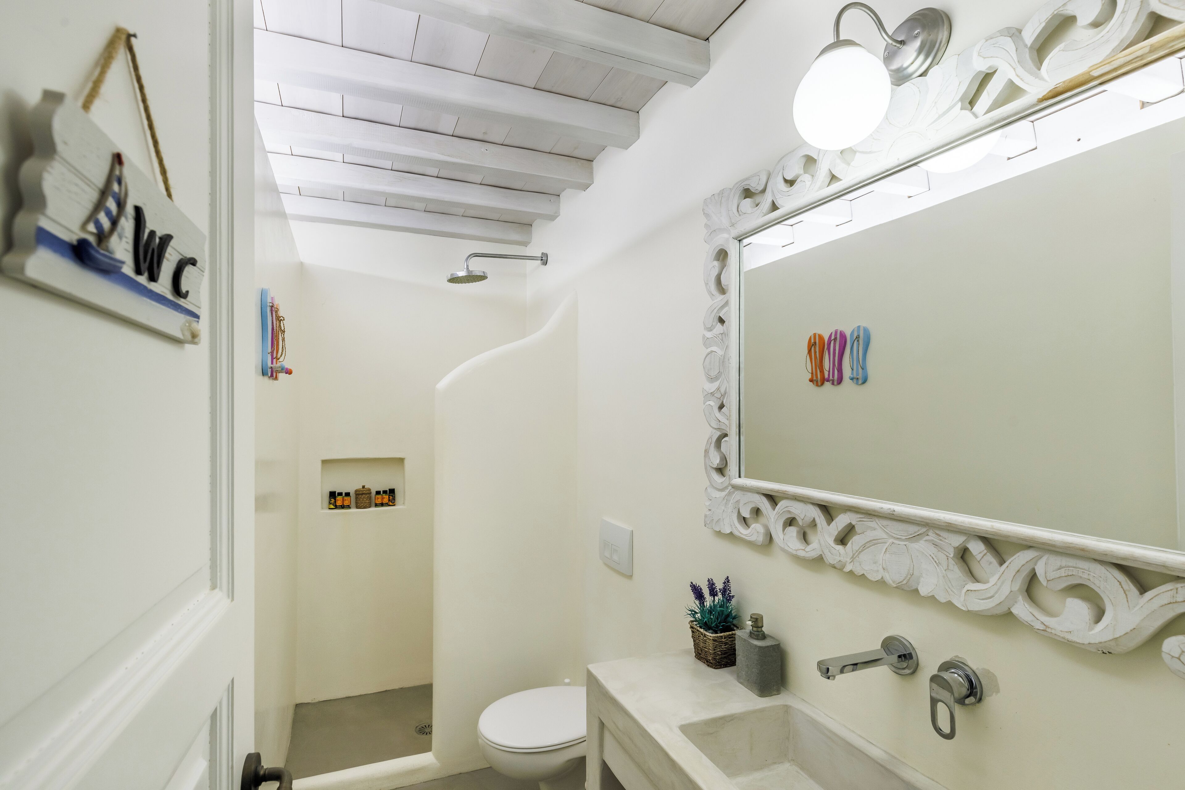 Une salle de bain avec un meuble-lavabo blanc, un grand miroir et une douche.