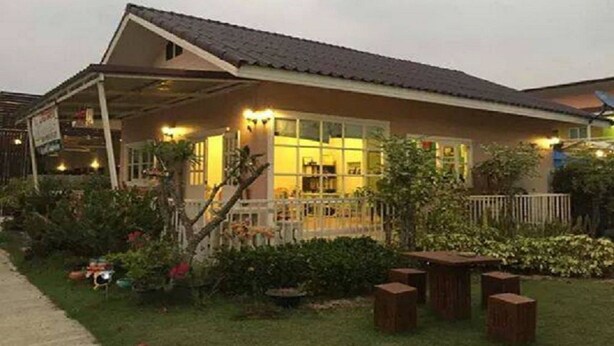 A building with a sloped roof, a covered porch, and a well-lit entrance. - Sweet Mango Resort (Sung Noen)