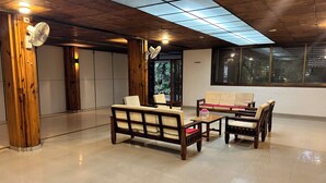 Un vestíbulo espacioso con mobiliario de madera, techo de cristal y vistas al exterior.