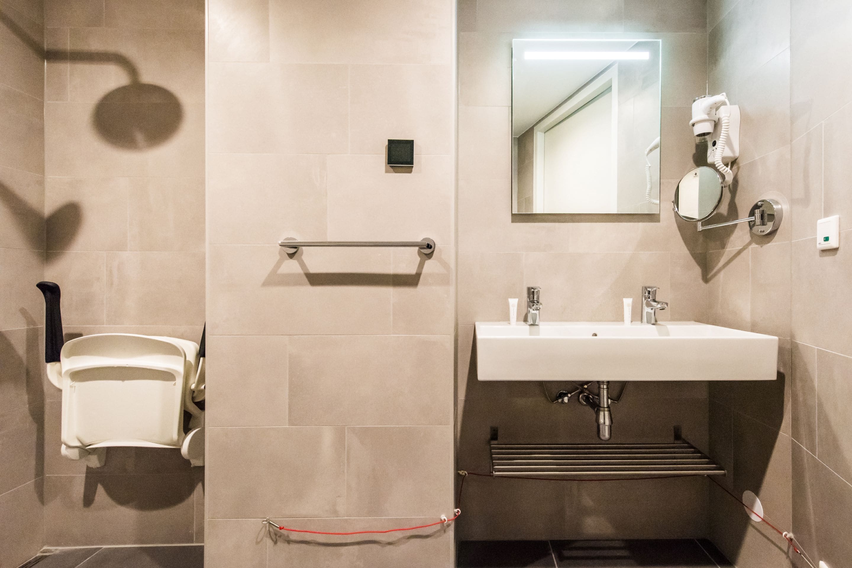 A modern bathroom with a toilet, sink, and mirror.