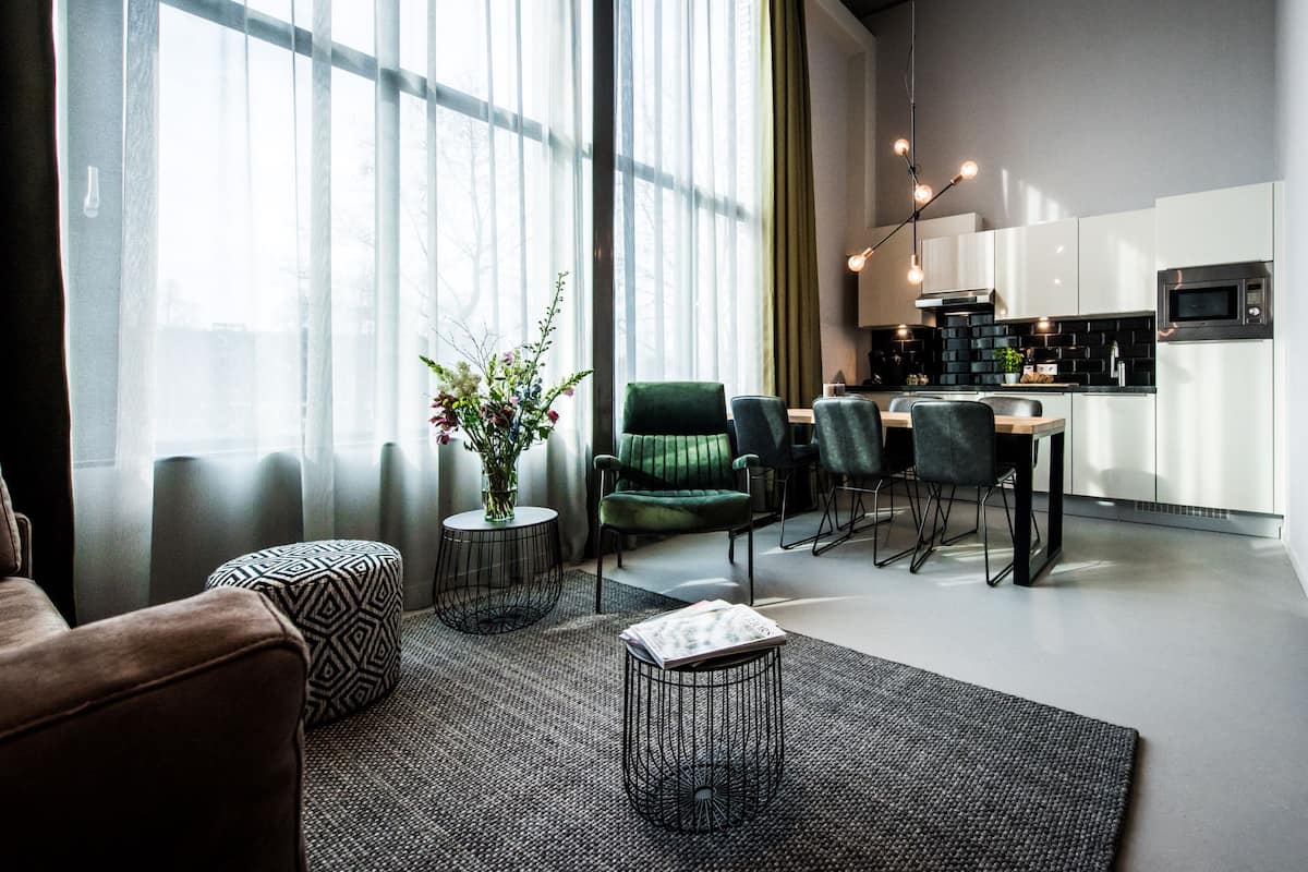 Ein modernes Wohnzimmer mit einer Couch, einem Couchtisch und einem Essbereich mit Stühlen und einem Tisch.