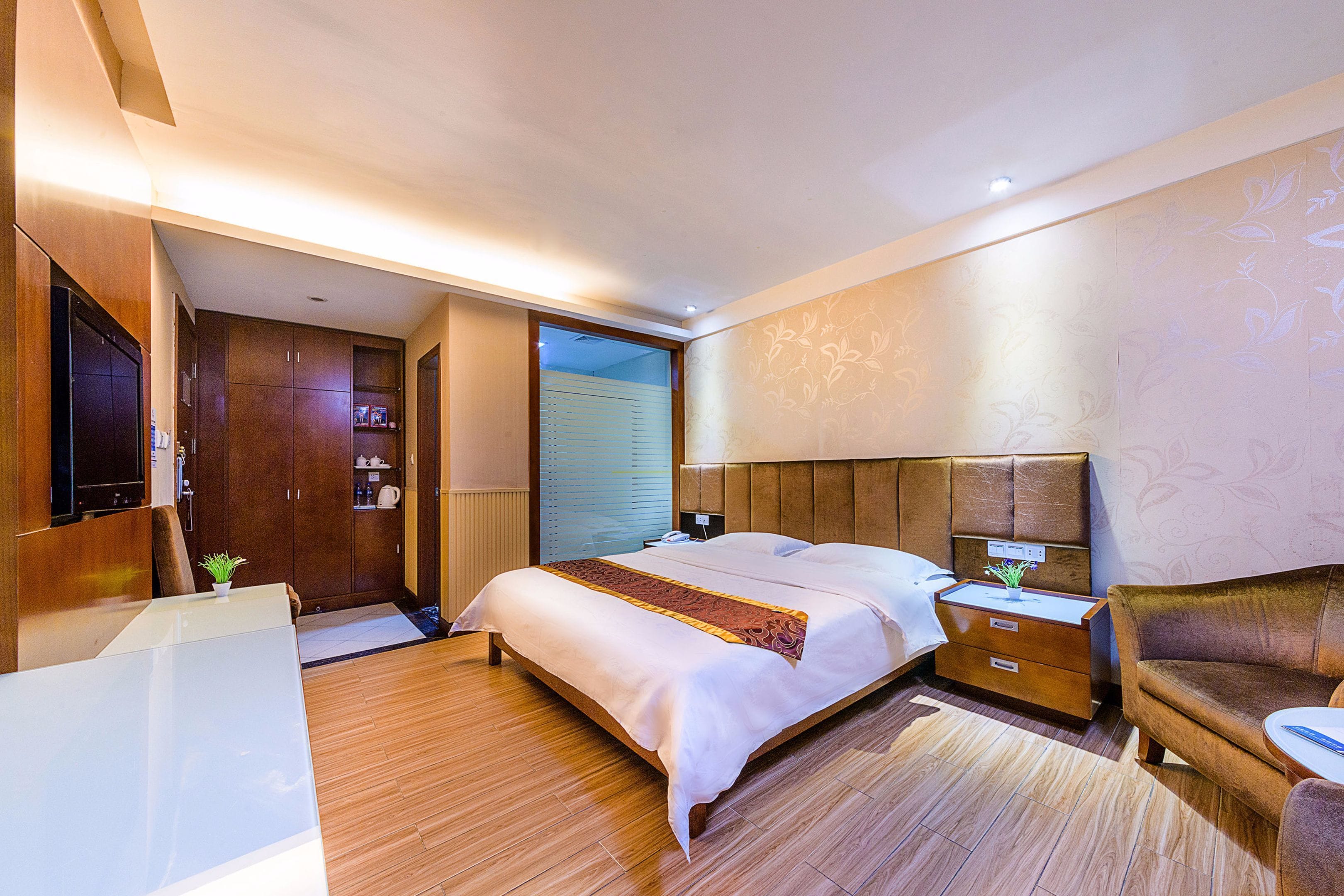 Una habitación de hotel moderna con una cama grande, un escritorio y un sofá.