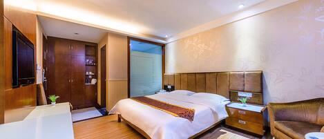 Una habitación de hotel moderna con una cama grande, un escritorio y un sofá.