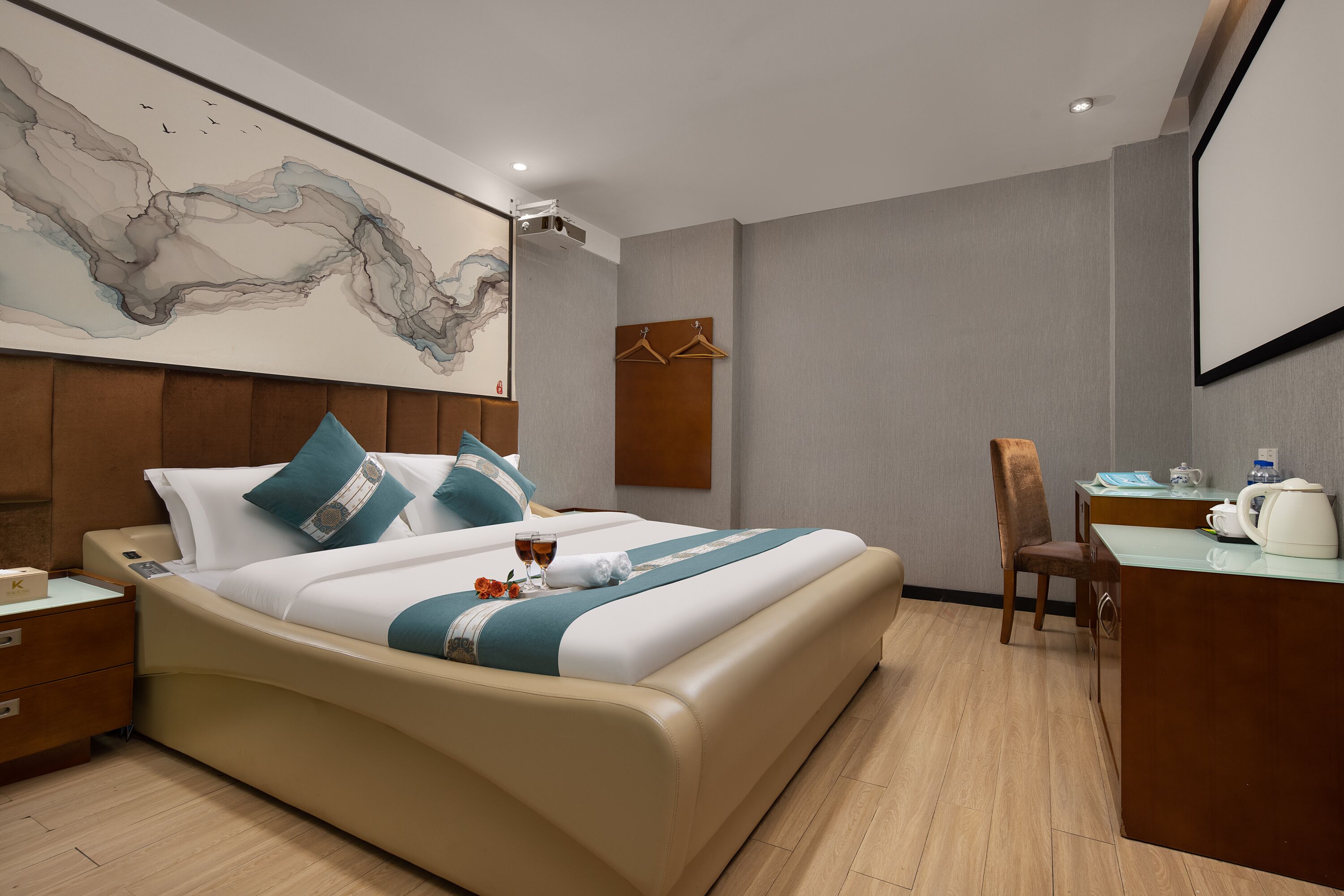 Ein modernes Hotelzimmer mit einem großen Bett, einem Schreibtisch und einem Stuhl.