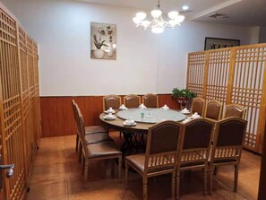 A dining area with a round table, eight chairs, and a chandelier. - Kaiserdom Hotel Airport Branch (Guangzhou)