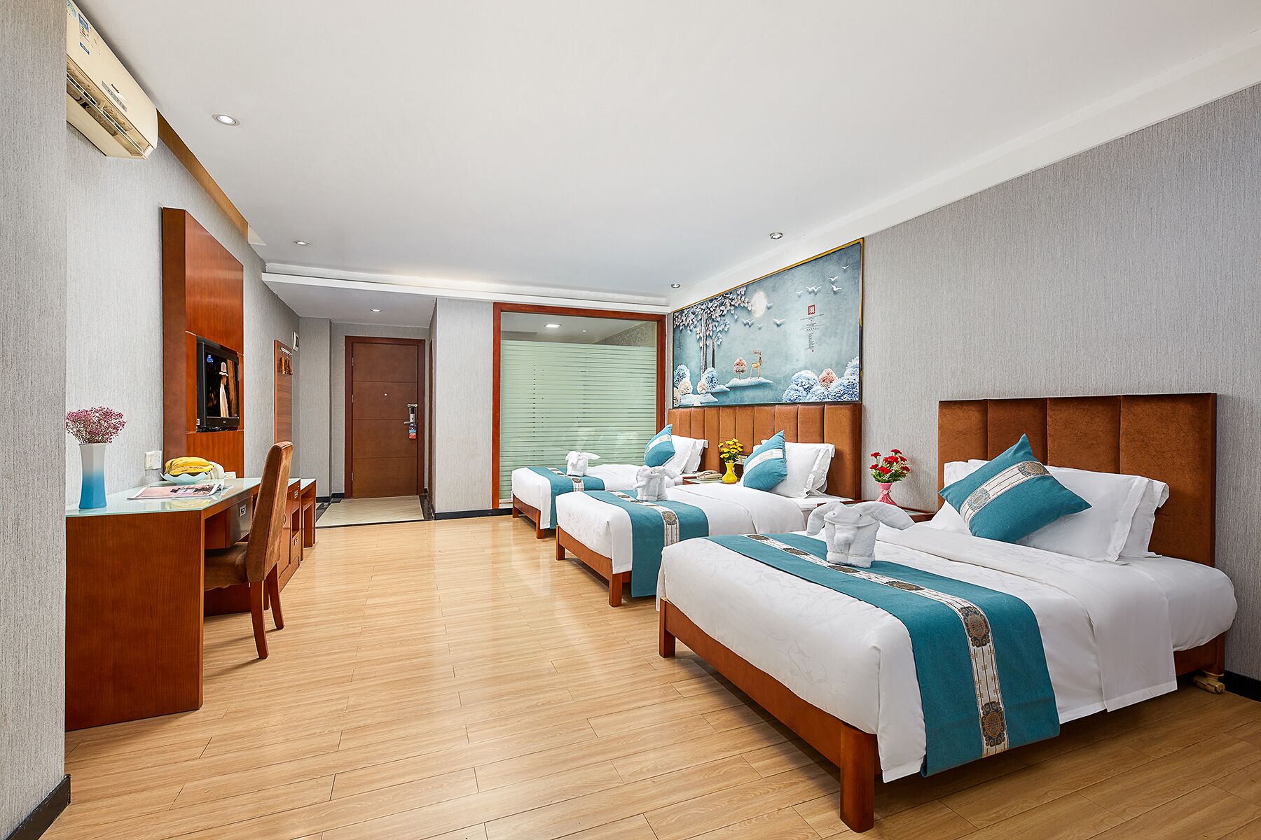 Quarto de hotel com duas camas, uma escrivaninha e uma cadeira.