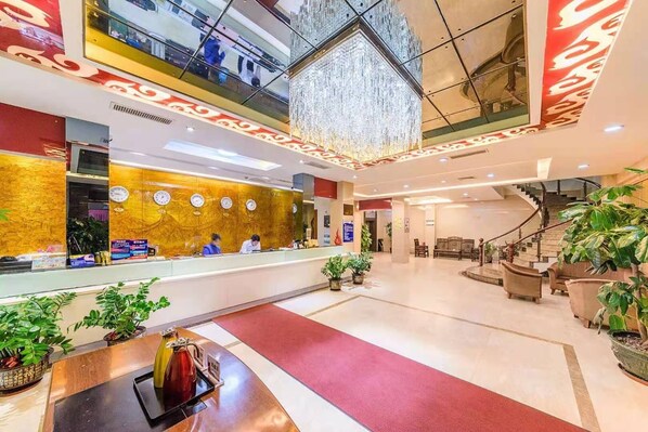 A hotel lobby with a reception desk, clocks, a chandelier, and a staircase. - Kaiserdom Hotel Airport Branch (Guangzhou)