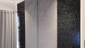 Une chambre moderne avec un grand lit, un ventilateur de plafond et un panneau décoratif mural.
