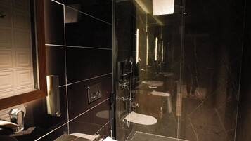 Ein modernes Badezimmer mit einem großen Spiegel, einem Waschbecken, einer Toilette und einer Duschkabine.