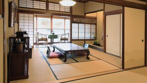 A traditional Japanese room with tatami flooring, a low table, and sliding doors. - Zen Oyado Nishitei (Fukuoka)