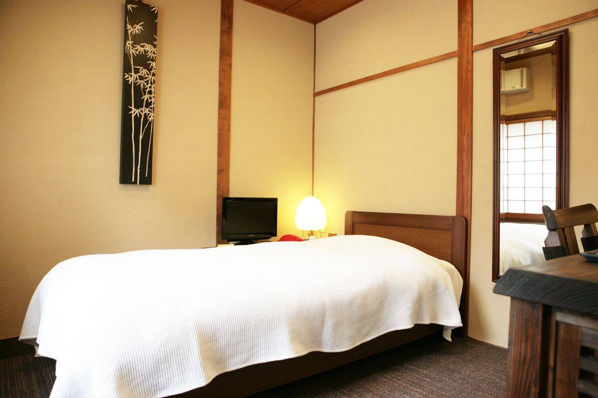 Une chambre d’hôtel avec un lit, une télévision, une table de chevet et une fenêtre.