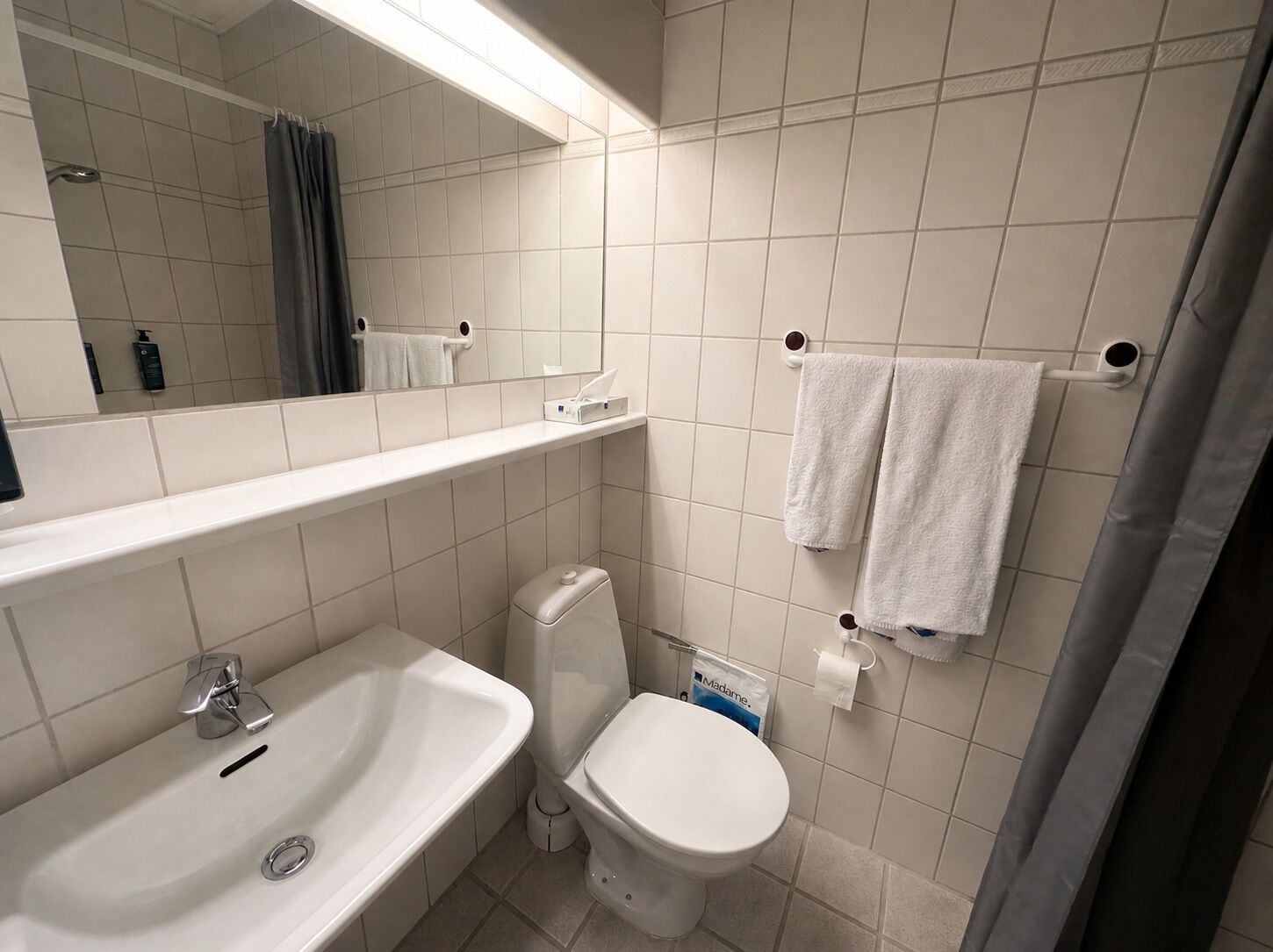 Un baño con lavabo, inodoro y espejo.