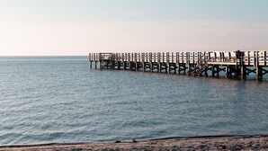Un muelle se adentra en aguas tranquilas bajo un cielo despejado.