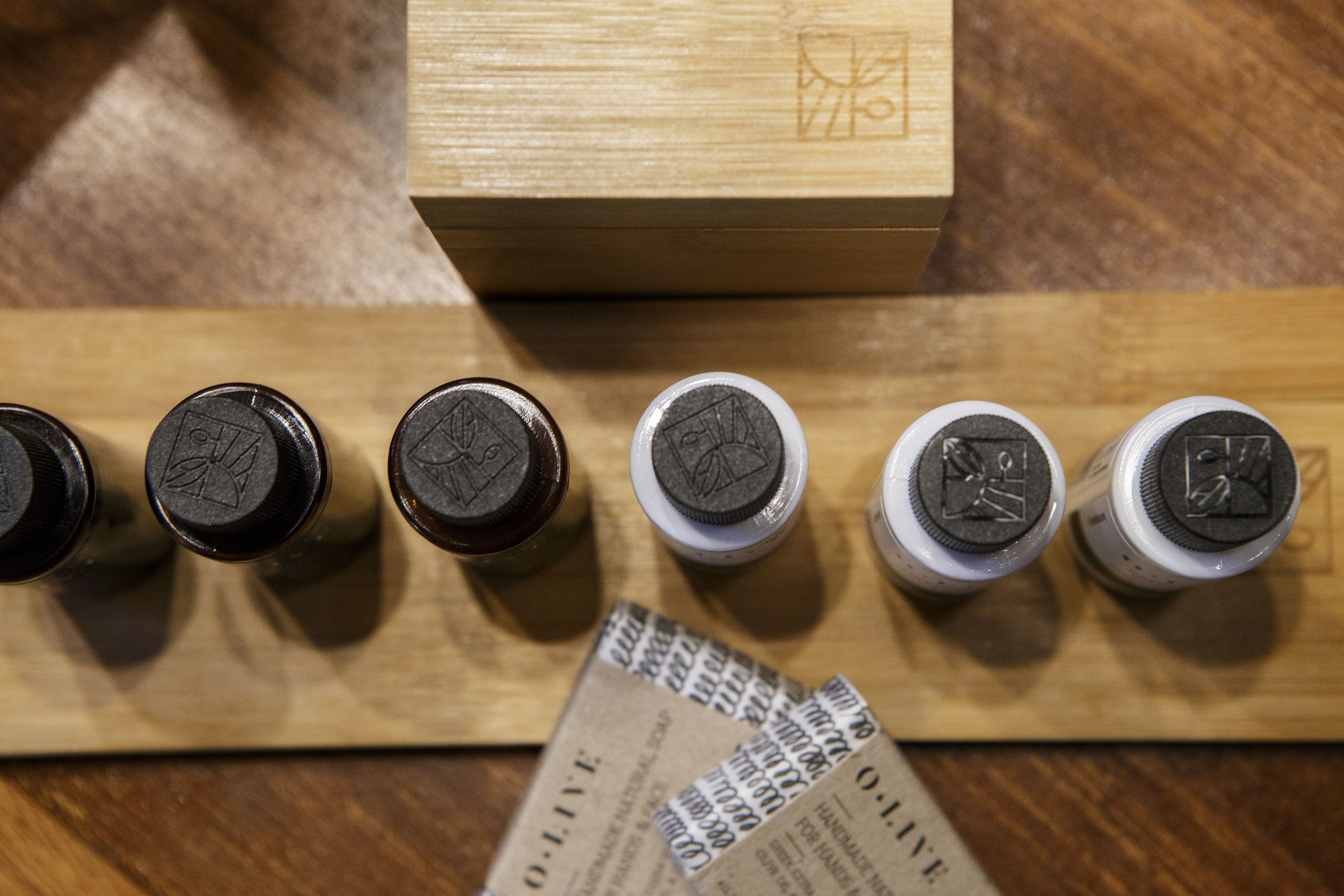A wooden surface with several ink bottles and a wooden box.