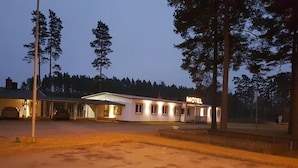 A motel with a single-story structure, a covered parking area, and a sign indicating its purpose. - Motoristen (Vara)