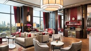A spacious lobby with a high ceiling, modern seating arrangements, and a view of the cityscape through large windows. - Shangri-La Jinan (Jinan)