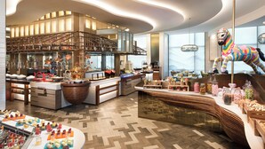 A modern hotel lobby with a central bar area, a staircase, and a large window offering a view of the cityscape. - Shangri-La Jinan (Jinan)
