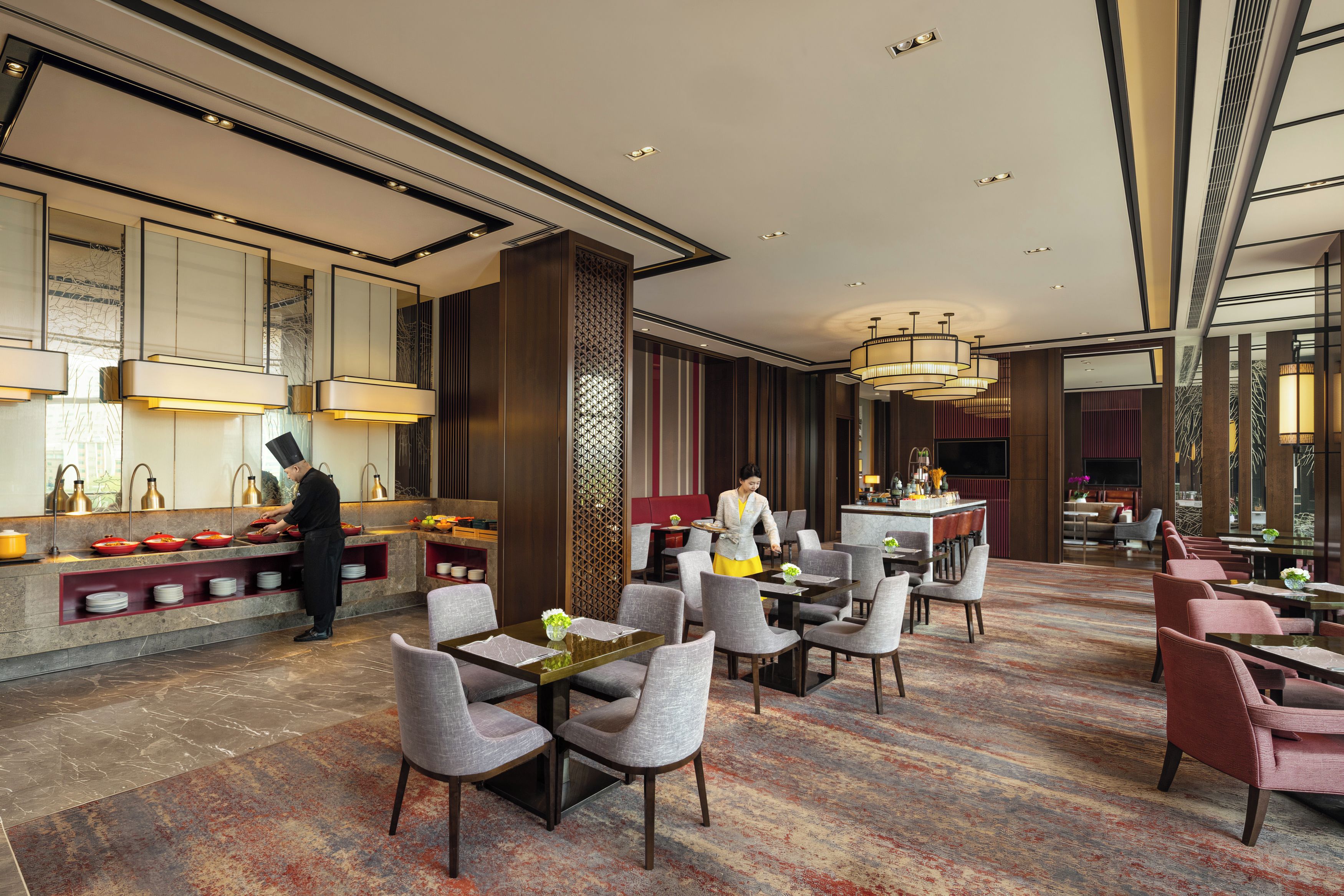 A hotel lobby with a bar area, seating arrangements, and a service counter.
