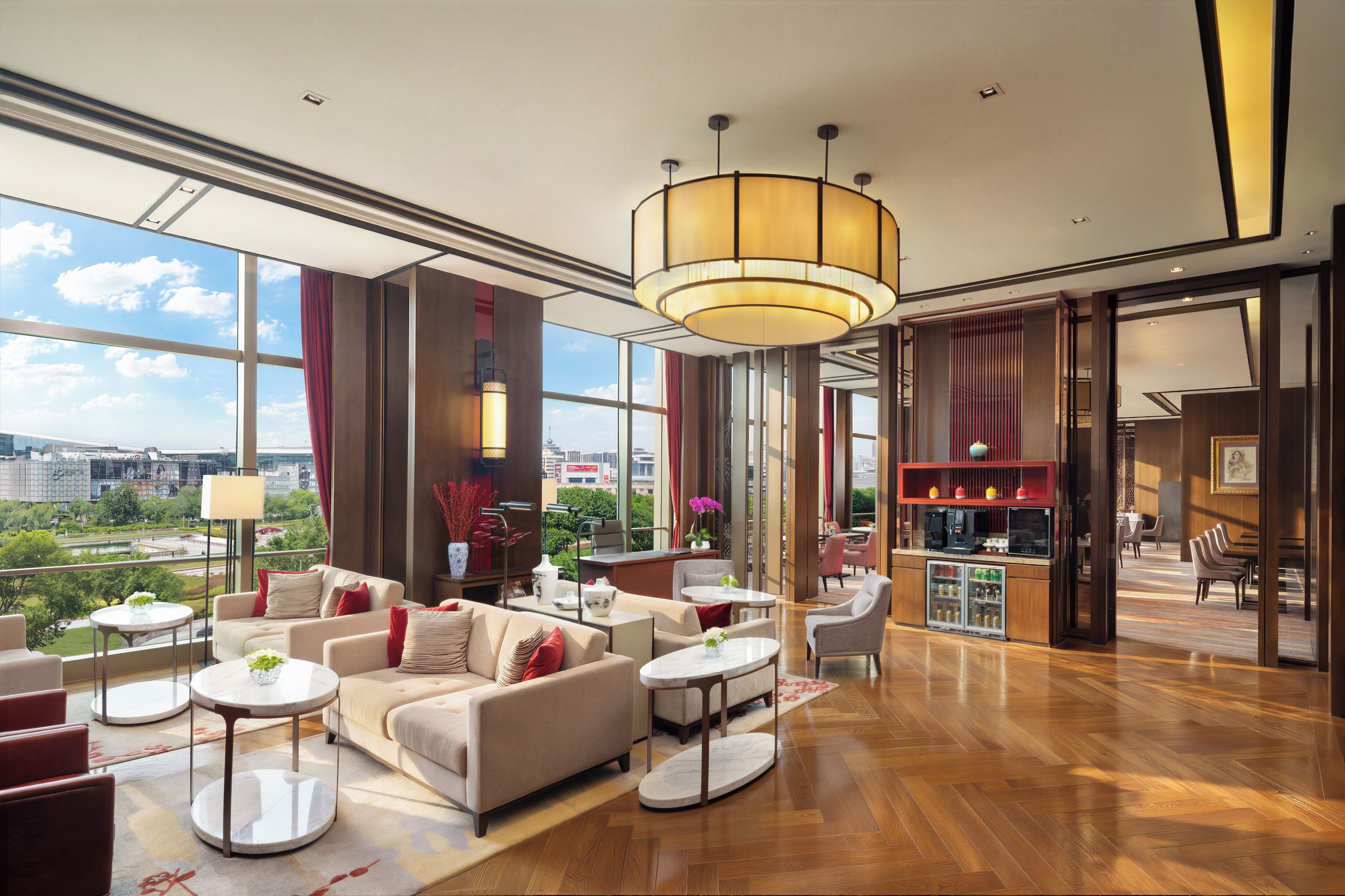 A spacious lobby with a high ceiling, large windows, and a view of the cityscape.