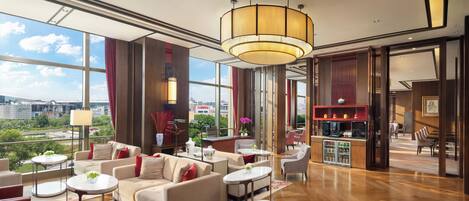 A spacious lobby with a high ceiling, large windows, and a view of the cityscape.