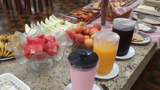A buffet setup with various food items, including fruits, vegetables, and beverages. - Grande Hotel Torres (Torres)