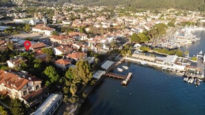 An aerial view of a coastal town with residential buildings, a marina, and a dock. - A&B Home Hotel (Fethiye)