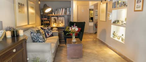 A living room with a sofa, a coffee table, a bookshelf, and a chair.