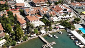 An aerial view of a coastal residential area with houses, a marina, and a swimming pool. - A&B Home Hotel (Fethiye)