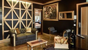 Um quarto luxuoso com um painel de parede grande e ricamente decorado, um sofá confortável, uma mesa de centro de madeira e uma garrafa de bebida.