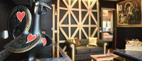 A bar area with a decorative helmet on a counter, a patterned wall, and a sofa in the background.