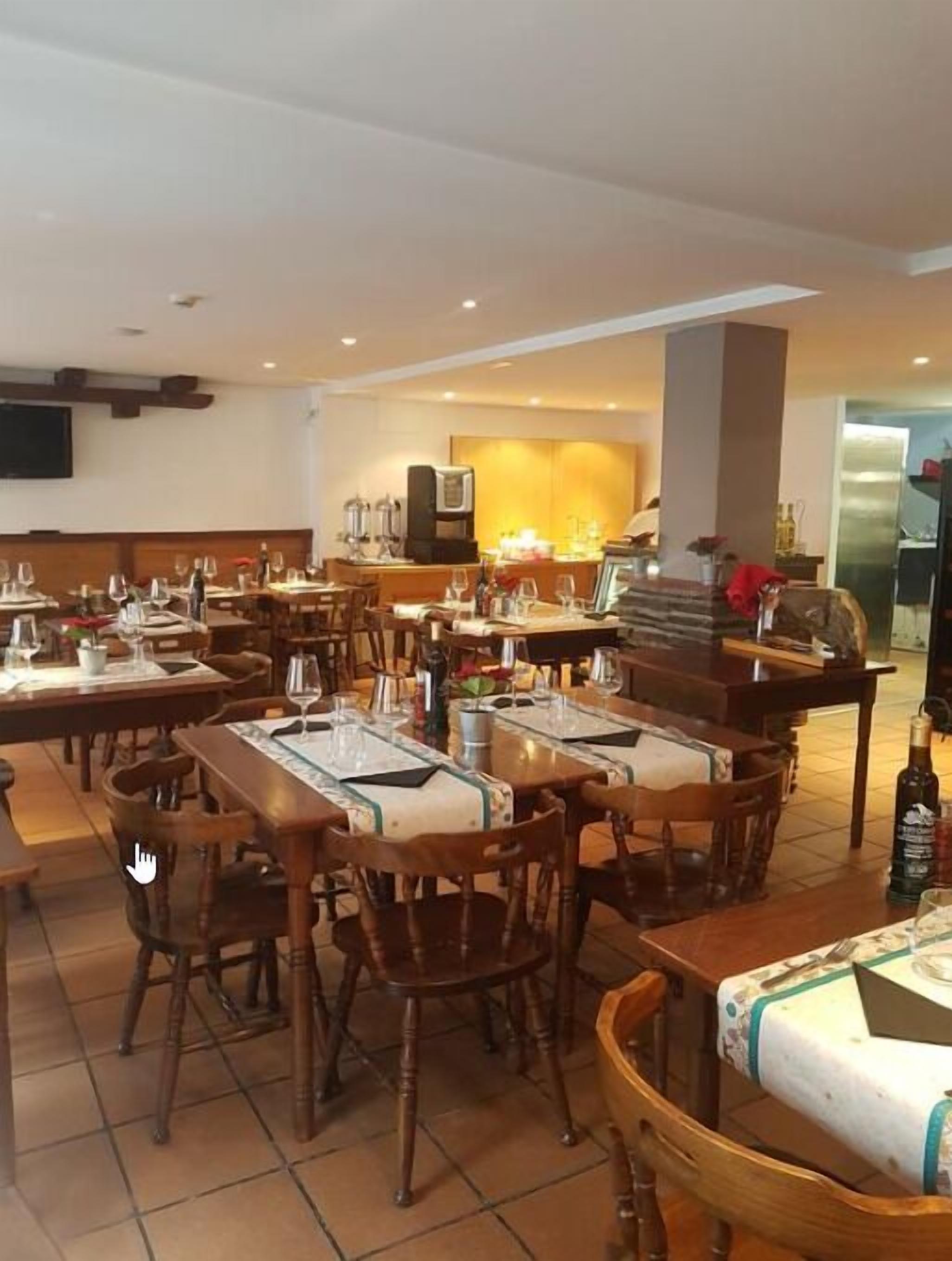 A restaurant with multiple tables set for dining, equipped with chairs and table settings.