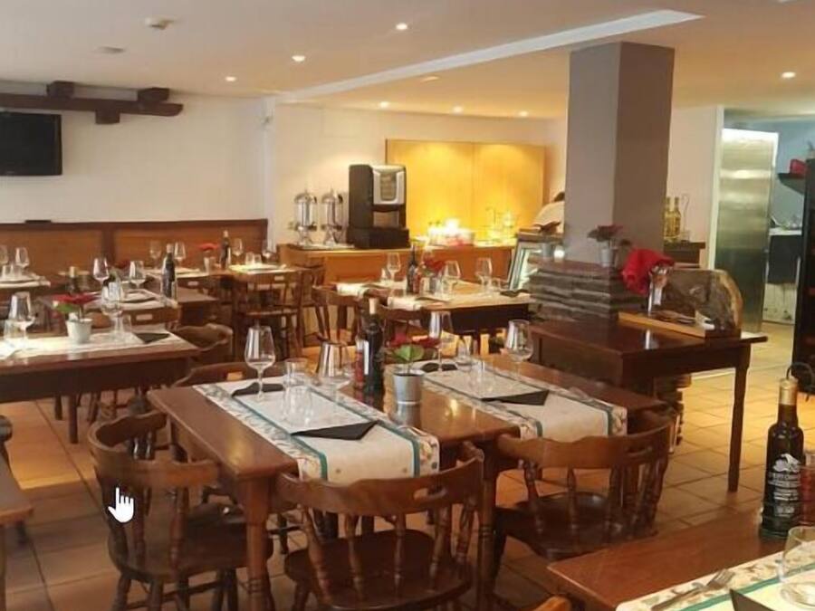 A restaurant with multiple tables set for dining, equipped with chairs and table settings.