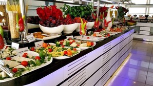 A buffet with various dishes including salads, fruits, and vegetables displayed on a counter. - Blue Garden Hotel (Konyaalti)