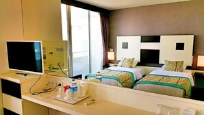 A hotel room with two beds, a TV, a desk with a computer, and a window with curtains. - Blue Garden Hotel (Konyaalti)